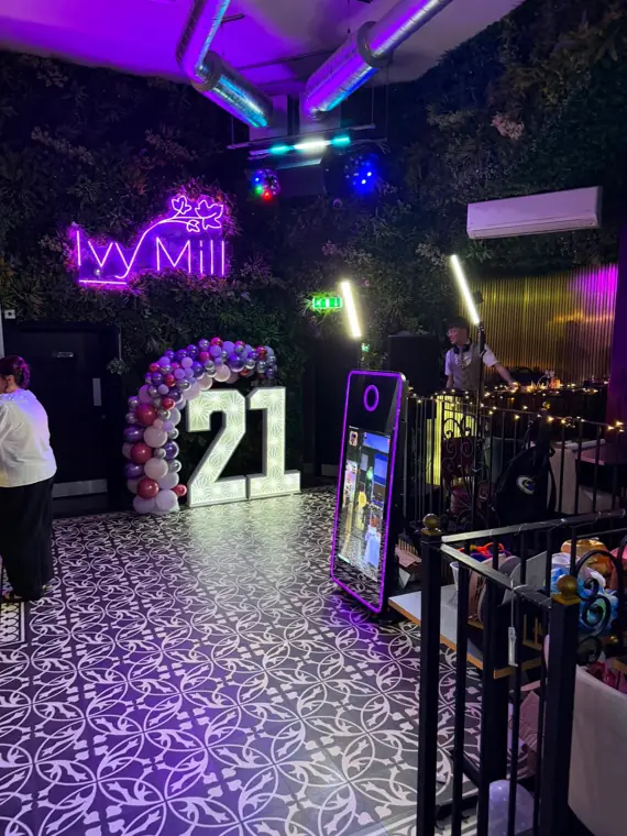 Magic Mirror booth and LED 21 numbers set up on the patterned dance floor at Ivy Mill, with the venue's neon sign and DJ in the background