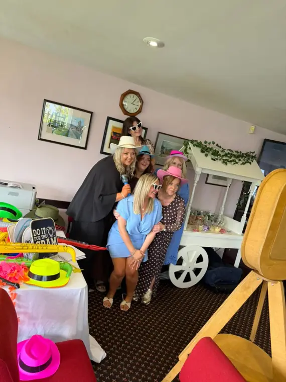 Group of guests with candy cart and photo booth at party