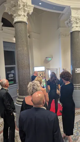 Guests queueing to use the Magic Mirror photo booth on a red carpet in the marble entrance of Greenock Town Hall